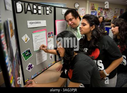 Oct. 6, 2010 - Sacramento, California, USA - LEDE-- Ralph Herrera, center, an internal medicine and pediatrics doctor at Kaiser works with students, l-r, Juanita Delgado, Claudia Vargas and Teresa Ortiz at Valley High School..Physicians from Kaiser Permanente South Sacramento Medical Center are helping juniors from the Valley High School's Health Tech Academy develop their presentations on issues such as heart disease, youth violence, colon cancer, HIV and diabetes..The Cultural Awareness and Community Health Education Outreach Project partners students from Valley High School's HealthTech Aca Stock Photo