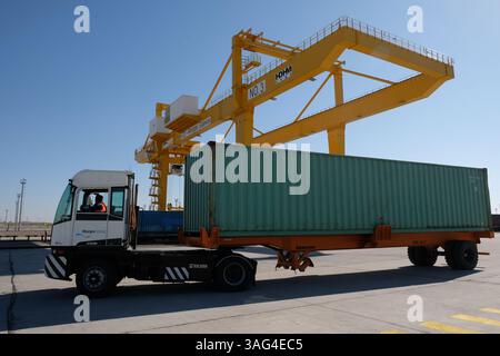 Unloading containers at the logistics center. Machines and cranes drag ...