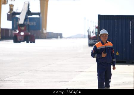 A security and control officer monitors the unloading of containers ...