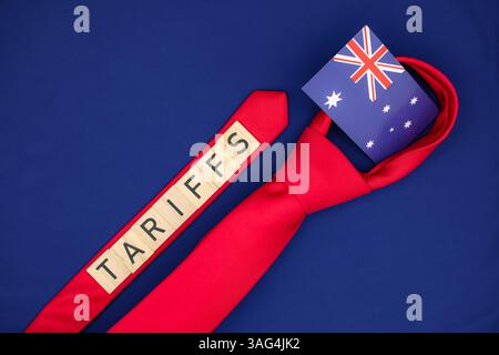 Symbolic Australian Flag is in the Loop of a Red Tie. 'Tariffs ' Word is on the Tie. US Tax Policy and Trade War Concept. Stock Photo