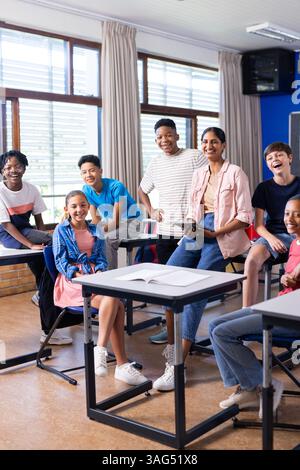 Group of students and Indian female teacher smiling in classroom, enjoying school environment Stock Photo