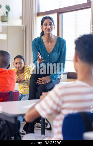 In school, Indian female teacher engaging with students, fostering interactive learning environment Stock Photo