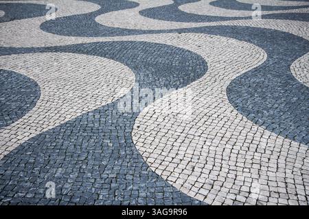 Stone mosaic waves on the street of Lisbon Portugal. Stock Photo