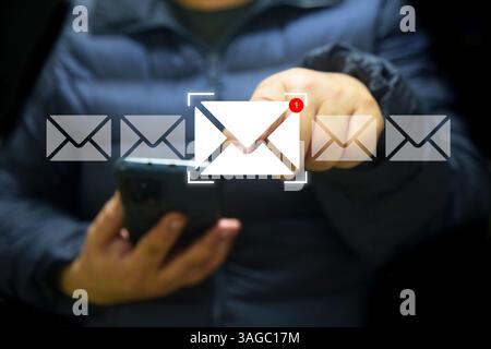 A business woman uses a laptop, with a glowing email icon and notification badge digitally superimposed, indicating a new message received in their in Stock Photo