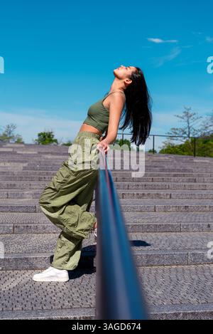 Beautiful and fit gen Z woman taking a break and relaxing in the sunlight Stock Photo