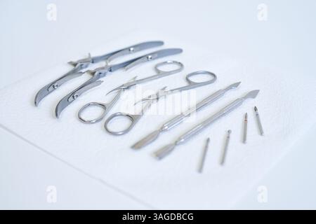 A set of clean and sterilized stainless steel medical tools arranged on a white paper towel Stock Photo