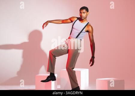 Stylish man posing confidently in studio wearing suspenders and trousers. Fashion, menswear, confidence, style, elegance, outfit Stock Photo