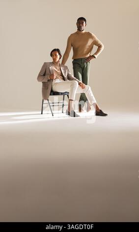 Confident men in stylish outfits posing in modern fashion studio. style, confidence, clothing Stock Photo