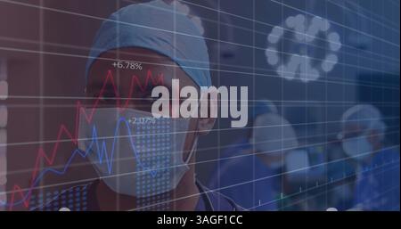 Financial data processing against portrait of male surgeon wearing face mask at hospital Stock Photo