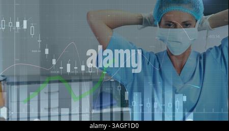 Financial data processing against portrait of female surgeon wearing face mask at hospital Stock Photo