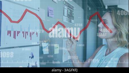 Image of numbers with red line statistics processing over businesswoman Stock Photo