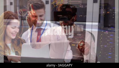 Man using VR headset over business colleagues working on laptop in office Stock Photo