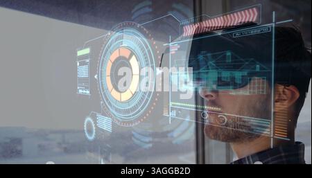 Wearing VR headset, man interacting with futuristic digital interface over architectural designs Stock Photo