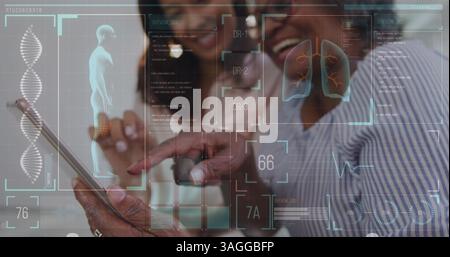 Image of medical data processing on digital screens over two women smiling and using tablet Stock Photo