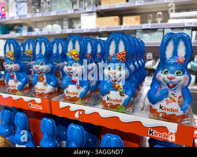 Colorful chocolate bunnies lined up on display in a cheerful shop during springtime celebration Stock Photo