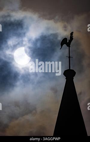 Picture shows the the partial eclipse in Ely,Cambridgeshire over the spire at St Mary’s Church on Saturday morning.    The partial solar eclipse will Stock Photo