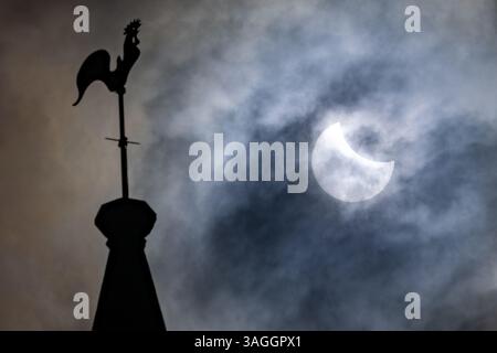 Picture shows the the partial eclipse in Ely,Cambridgeshire over the spire at St Mary’s Church on Saturday morning.    The partial solar eclipse will Stock Photo