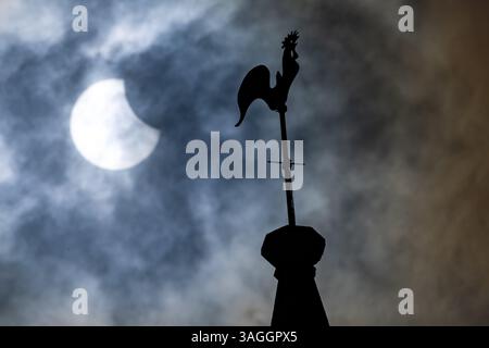 Picture shows the the partial eclipse in Ely,Cambridgeshire over the spire at St Mary’s Church on Saturday morning.    The partial solar eclipse will Stock Photo