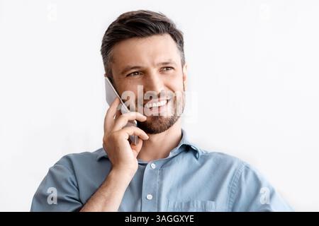 Business Communication. Successful Businessman Sitting At Workplace Talking On Cellphone With Client Stock Photo
