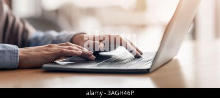 Unrecognizable woman typing on laptop at cafe Stock Photo