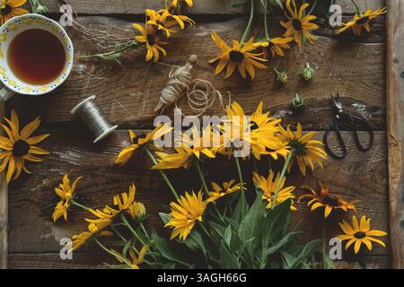 Overhead shot of yellow flowers on rustic wooden table Stock Photo