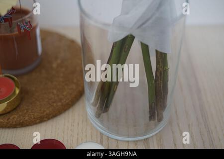 Empty glass transparent vase with dead wilted flowers on the table. No water flowers bouquet Stock Photo