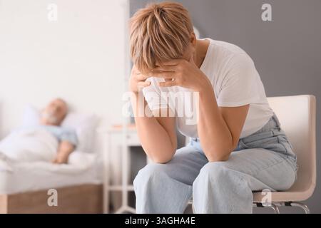 Sad mature woman and her sick husband in bedroom Stock Photo