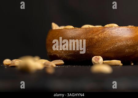 fried peanut kernels in a wooden bowl, fried yellow peanuts with a little salt on the table Stock Photo