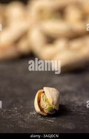 cracked pistachios with green nuts inside, the salted pistachios on the table Stock Photo