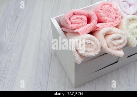Fluffy pink folded towels on a light surface, top view, perfect for design mockups with space for promotional content. Stock Photo
