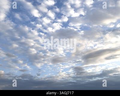 Overcast cloudy sky with many clouds at dusk grey stratocumulus below in the middle altostratus white cirrocumulus above, international Stock Photo
