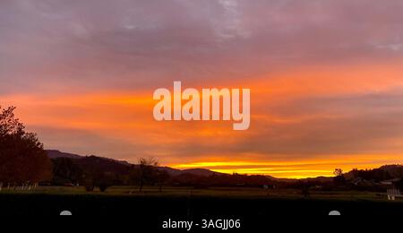 Fiery Sunset Over Rolling Hills Stock Photo