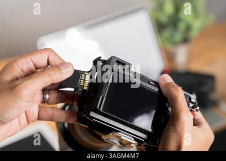 Photographer's hand holding memory card for preparing his camera before photography. SD Card with camera. Inserting high-capacity memory card into pho Stock Photo