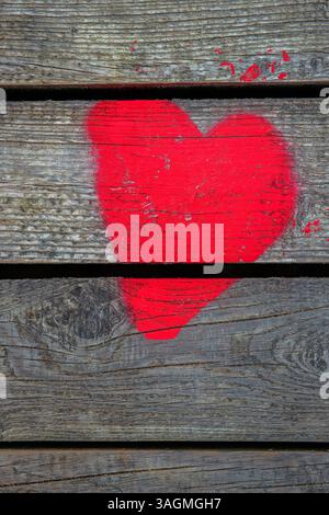 Love heart spray painted on wooden wall background. One red heart on wood boards fence backdrop. Happy Valentines day. 14th February Wallpaper, design Stock Photo