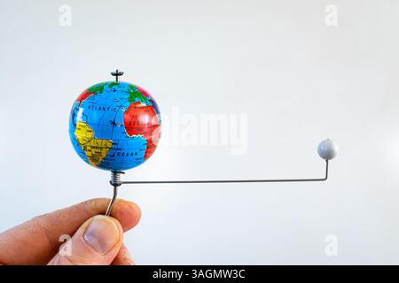 Person is holding a simple demonstration model to show the rotation of the moon around the earth. Used in geography or physics class. Stock Photo