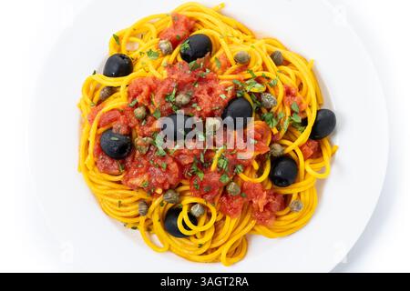 Italian Pasta puttanesca with tomato sauce, capers, and black olives isolated on white background Stock Photo