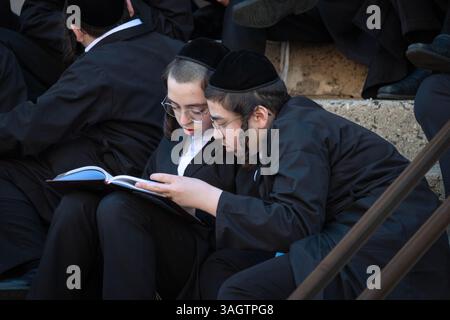 During recess at a yeshiva, 2 orthodox Jewish student studies together on the steps of their school. In Brooklyn, NY. Stock Photo