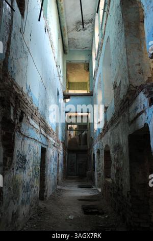 A dark corridor in an abandoned building. Destroyed houses. Stock Photo