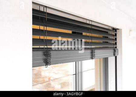 Modern tilt and turn balcony doors with closed roller shutters in contemporary apartment. Stock Photo
