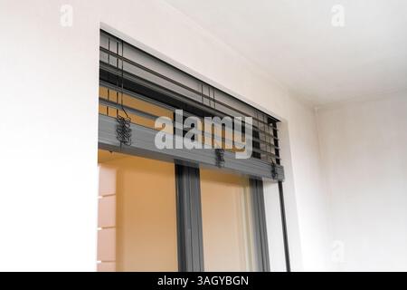 Tilt and turn window and door system with closed roller shutters in a modern apartment balcony Stock Photo