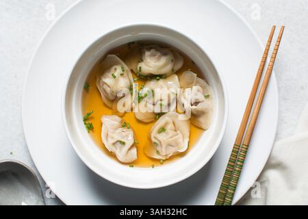 Overhead view of wonton soup in a white ceramic bowl, clear soup with dumplings in a white soup bowl Stock Photo