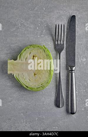 cabbage cross section and cutlery fork and knife on a gray stone table. healthy dietary concept. top view Stock Photo