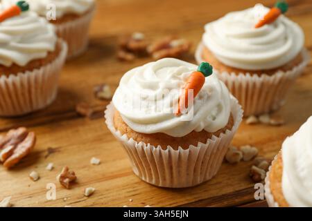 Delicious carrot cupcakes and walnuts on wooden table, closeup Stock Photo