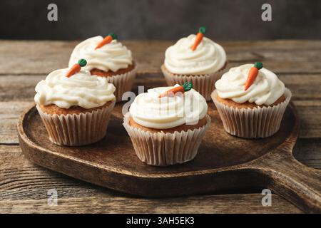 Delicious carrot cupcakes on wooden table against grey background, closeup Stock Photo