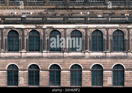 Facade of an old building, with arched windows against a stone wall and a large balcony with stone balusters.  From the series Windows of the World. Stock Photo