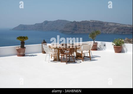 Stylish Wooden Outdoor Furniture on Greek Terrace with Sea View in Oia, Greece Stock Photo