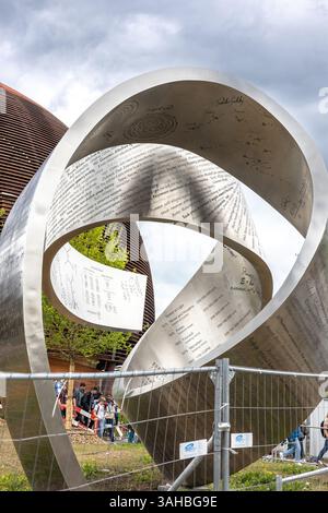A metallic Mobius strip sculpture inscribed with scientific equations and names stands in front of the Globe of Science and Innovation at CERN. The territory of Large Hadron Collider. 20 June 2023. High quality photo Stock Photo
