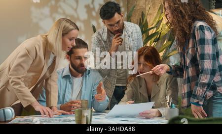 Multiracial multiethnic group coworking office team business women men girls guys male female students coworkers architects paperwork discussion Stock Photo
