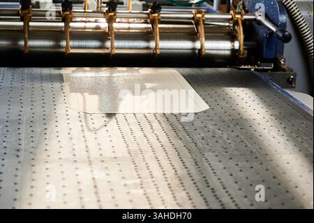 Glue-spreading machine efficiently applies adhesive during cardboard box assembly in a manufacturing plant Stock Photo
