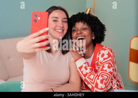 African American and Caucasian students taking selfie while studying at home Stock Photo